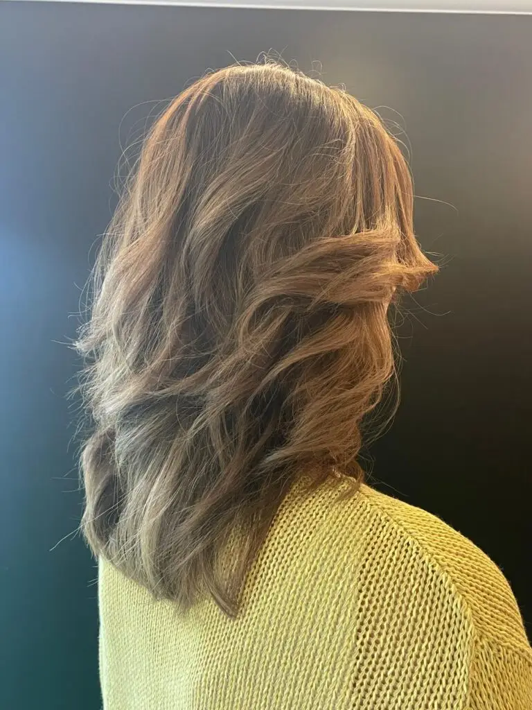 Bruin haar met warme highlights en golven - Kapsalon Steff Bertem
